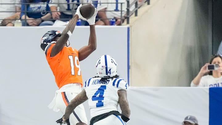 Denver Broncos wide receiver Marvin Mims Jr. (19) makes a catch for a touchdown as Indianapolis Colts cornerback Xavien Howard (4) gives chase Sunday, Sept. 14, 2025, during a game at Lucas Oil Stadium in Indianapolis.