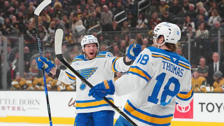 Jan 10, 2026; Las Vegas, Nevada, USA; St. Louis Blues left wing Jake Neighbours (63) celebrates a goal scored against the Vegas Golden Knights by center Robert Thomas (18) during the first period at T-Mobile Arena. Mandatory Credit: Stephen R. Sylvanie-Imagn Images