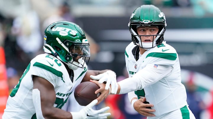 New York Jets quarterback Zach Wilson (2) hands the ball to running back Breece Hall (20) in the