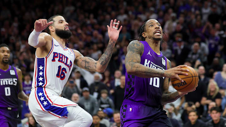 Jan 1, 2025; Sacramento, California, USA; Sacramento Kings forward DeMar DeRozan (10) drives to the basket against Philadelphia 76ers forward Caleb Martin (16) during the fourth quarter at Golden 1 Center. Mandatory Credit: Sergio Estrada-Imagn Images