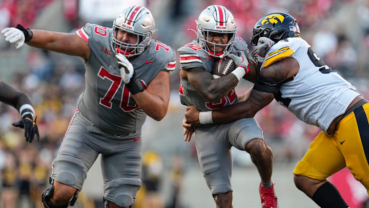 Oct 5, 2024; Columbus, OH, USA; Ohio State Buckeyes running back TreVeyon Henderson (32) runs through Iowa Hawkeyes defensive lineman Caden Crawford (97) with a block from offensive lineman Josh Fryar (70) during the second half of the NCAA football game at Ohio Stadium. Ohio State won 35-7. Oct 5, 2024; Columbus, OH, USA; Ohio State Buckeyes running back TreVeyon Henderson (32) runs through Iowa Hawkeyes defensive lineman Caden Crawford (97) with a block from offensive lineman Josh Fryar (70) during the second half of the NCAA football game at Ohio Stadium. Ohio State won 35-7.
