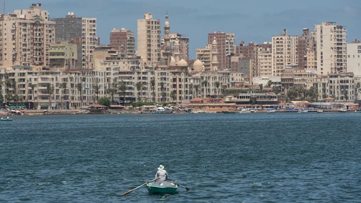 A lone Egyptian fishermen in a small boat fishing in the...