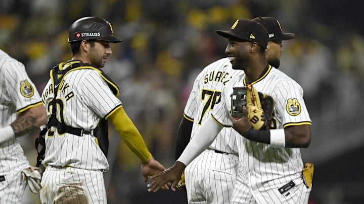 Oct 8, 2024; San Diego, California, USA; San Diego Padres catcher Kyle Higashioka (20) and outfielder Jurickson Profar (10) celebrate after defeating the Los Angeles Dodgers during game three of the NLDS for the 2024 MLB Playoffs at Petco Park.  Mandatory Credit: Denis Poroy-Imagn Images