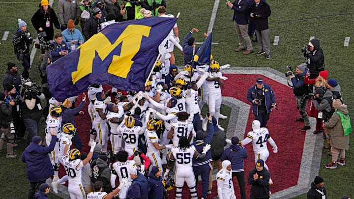 Michigan football players plant their team's flag at midfield following their game against the Ohio State Buckeyes at Ohio Stadium. 