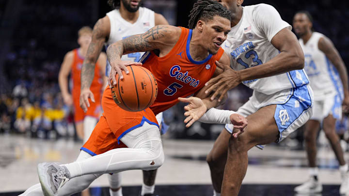 Dec 17, 2024; Charlotte, North Carolina, USA; Florida Gators guard Will Richard (5) drives to the basket against North Carolina Tar Heels forward Jalen Washington (13) during the second half at Spectrum Center. Mandatory Credit: Jim Dedmon-Imagn Images Dec 17, 2024; Charlotte, North Carolina, USA; Florida Gators guard Will Richard (5) drives to the basket against North Carolina Tar Heels forward Jalen Washington (13) during the second half at Spectrum Center. Mandatory Credit: Jim Dedmon-Imagn Images