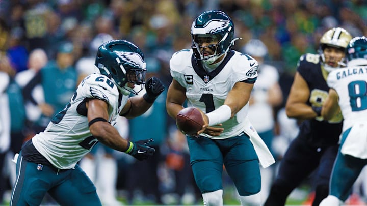 Sep 22, 2024; New Orleans, Louisiana, USA; Philadelphia Eagles quarterback Jalen Hurts (1) hands off to running back Saquon Barkley (26) against the New Orleans Saints during the second half at Caesars Superdome.  