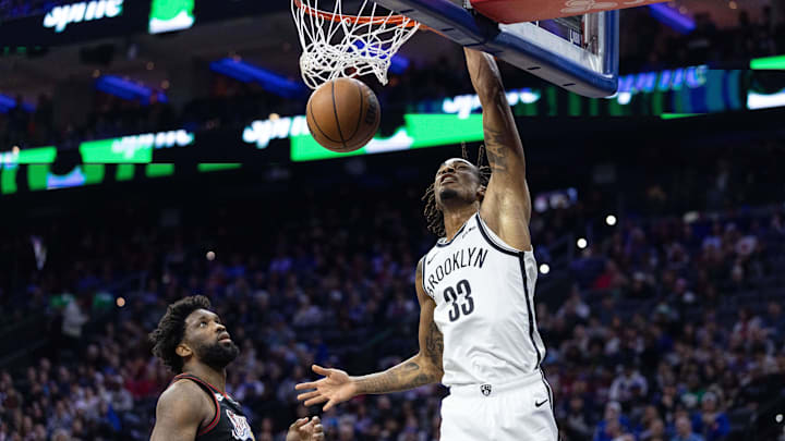 Dec 23, 2025; Philadelphia, Pennsylvania, USA; Brooklyn Nets center Nic Claxton (33) dunks the ball in front of Philadelphia 76ers center Joel Embiid (21) during the second quarter at Xfinity Mobile Arena. Mandatory Credit: Bill Streicher-Imagn Images