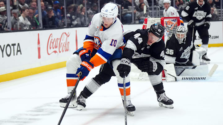 Mar 11, 2025; Los Angeles, California, USA; New York Islanders right wing Simon Holmstrom (10) and LA Kings defenseman Mikey Anderson (44) battle for the puck in the third period at the Crypto.com Arena. Mandatory Credit: Kirby Lee-Imagn Images