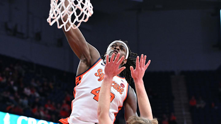 Dec 20, 2025; Syracuse, New York, USA; Syracuse Orange forward William Kyle III (42) dunks the ball over Northeastern Huskies guard Luca Soroa Schaller (13) in the second half at the JMA Wireless Dome. Mandatory Credit: Mark Konezny-Imagn Images