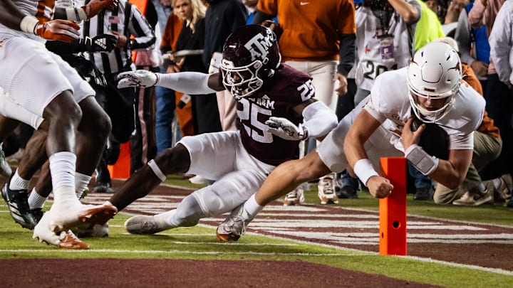 Nov 30, 2024; College Station, Texas, USA; Texas Longhorns quarterback Arch Manning (16) dives for a touchdown against Texas A&M Aggies defensive back Dalton Brooks (25) in the first quarter at Kyle Field.