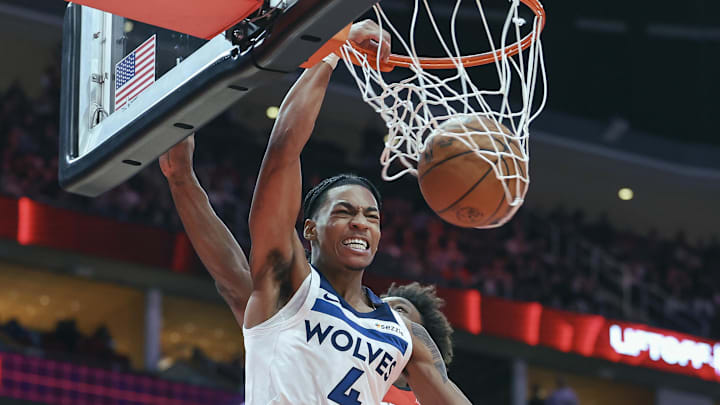 Feb 21, 2025; Houston, Texas, USA; Minnesota Timberwolves guard Rob Dillingham (4) dunks the ball as Houston Rockets forward Jae'Sean Tate (8) defends during the third quarter at Toyota Center. Mandatory Credit: Troy Taormina-Imagn Images
