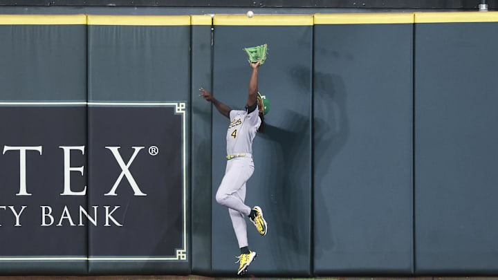 Jul 26, 2025; Houston, Texas, USA; Athletics center fielder Lawrence Butler (4) makes a catch at the wall during the fourth inning against the Houston Astros at Daikin Park. Mandatory Credit: Troy Taormina-Imagn Images