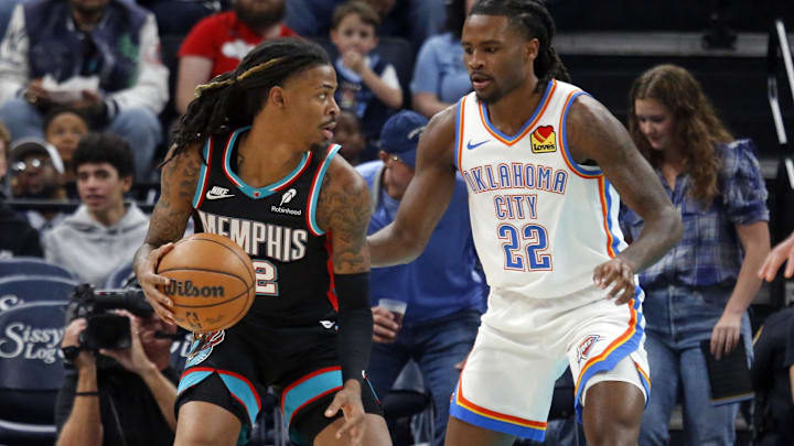 Nov 9, 2025; Memphis, Tennessee, USA; Memphis Grizzlies guard Ja Morant (12) dribbles as Oklahoma City Thunder guard Cason Wallace (22) defends during the first quarter at FedExForum. Mandatory Credit: Petre Thomas-Imagn Images