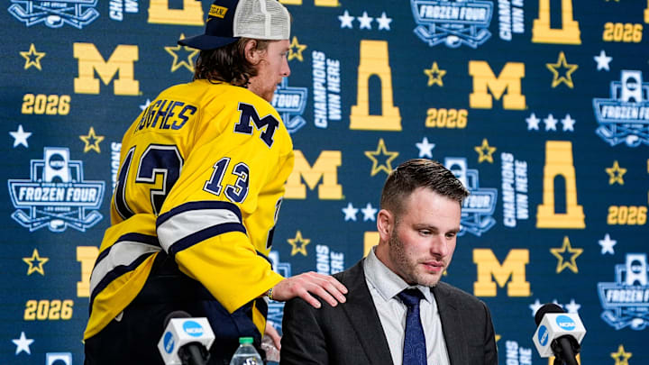 Michigan forward T.J. Hughes comforts head coach Brandon Naurato as leave the post game press conference after 4-3 loss to Denver in the two overtimes at the Frozen Four semifinal at T-Mobile Arena in Las Vegas on Thursday, April 9, 2026