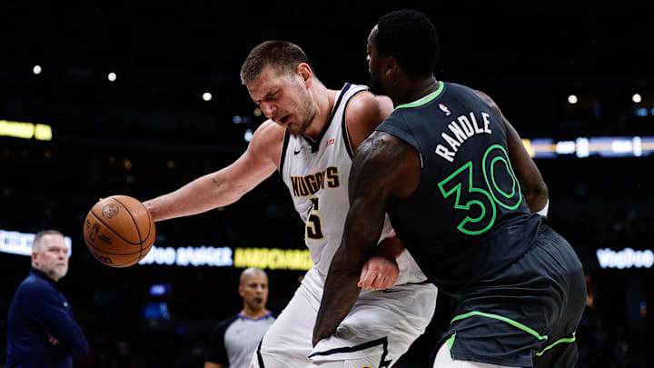 Apr 1, 2025; Denver, Colorado, USA; Denver Nuggets center Nikola Jokic (15) is fouled by Minnesota Timberwolves forward Julius Randle (30) in the fourth quarter at Ball Arena. Mandatory Credit: Isaiah J. Downing-Imagn Images