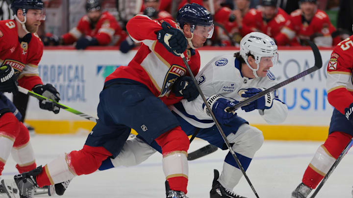 Mar 3, 2025; Sunrise, Florida, USA; Tampa Bay Lightning center Michael Eyssimont (23) attempts to move the puck past Florida Panthers defenseman Nate Schmidt (88) during the first period at Amerant Bank Arena. Mandatory Credit: Sam Navarro-Imagn Images