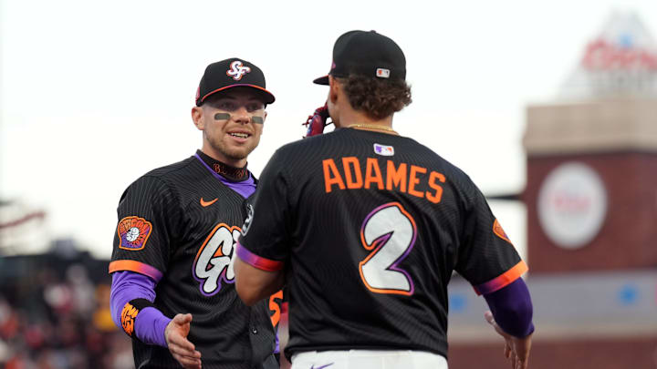 Aug 16, 2025; San Francisco, California, USA; San Francisco Giants third baseman Christian Koss (left) and shortstop Willy Adames (2) talk during the seventh inning against the Tampa Bay Rays at Oracle Park. Mandatory Credit: Darren Yamashita-Imagn Images