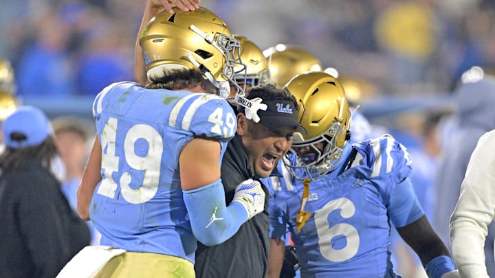 Nov 8, 2024; Pasadena, California, USA;   UCLA Bruins defensive coordinator Ikaika Malloe, center, celebrates with linebacker Carson Schwesinger (49) defensive back Jaylin Davies (6) after an interception in the second half against the Iowa Hawkeyes at the Rose Bowl. Mandatory Credit: Jayne Kamin-Oncea-Imagn Images