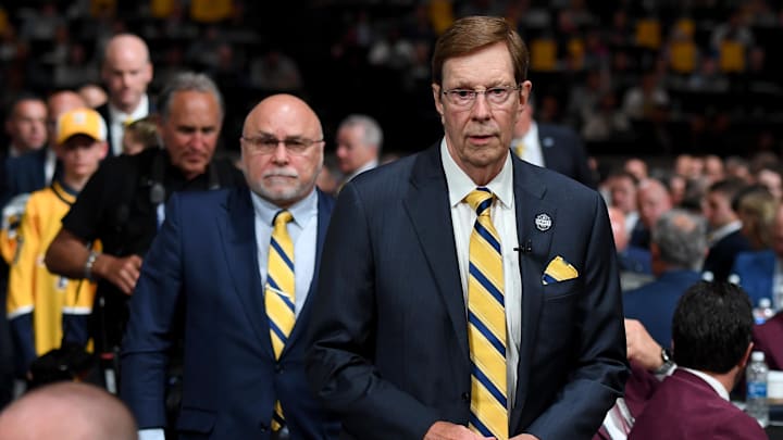 Nashville Predators outgoing general manager David Poile walks to the stage in front of incoming general manager Barry Trotz: Christopher Hanewinckel-Imagn Images
