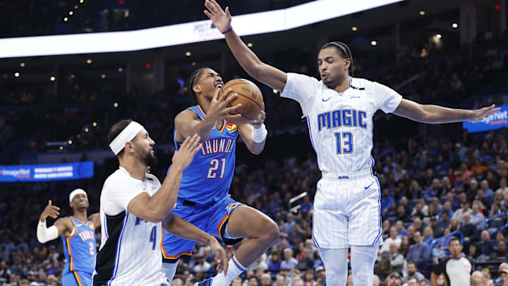 Nov 4, 2024; Oklahoma City, Oklahoma, USA; Oklahoma City Thunder guard Aaron Wiggins (21) shoots between Orlando Magic guard Jalen Suggs (4) and guard Jett Howard (13) during the second half at Paycom Center. Mandatory Credit: Alonzo Adams-Imagn Images Nov 4, 2024; Oklahoma City, Oklahoma, USA; Oklahoma City Thunder guard Aaron Wiggins (21) shoots between Orlando Magic guard Jalen Suggs (4) and guard Jett Howard (13) during the second half at Paycom Center. Mandatory Credit: Alonzo Adams-Imagn Images