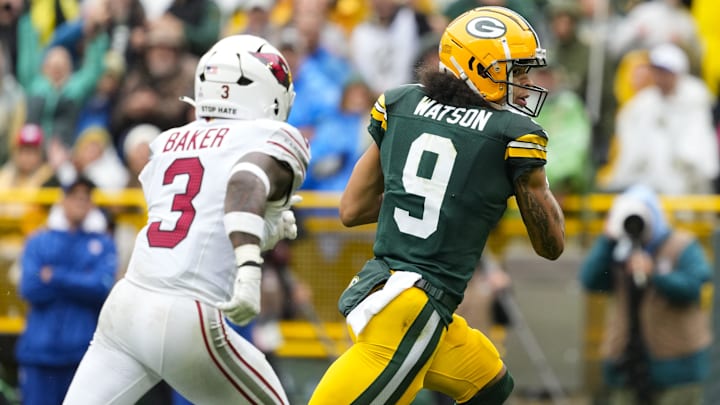 Oct 13, 2024; Green Bay, Wisconsin, USA;  Green Bay Packers wide receiver Christian Watson (9) scores a touchdown in front of Arizona Cardinals safety Budda Baker (3) during the second quarter at Lambeau Field. Mandatory Credit: Jeff Hanisch-Imagn Images