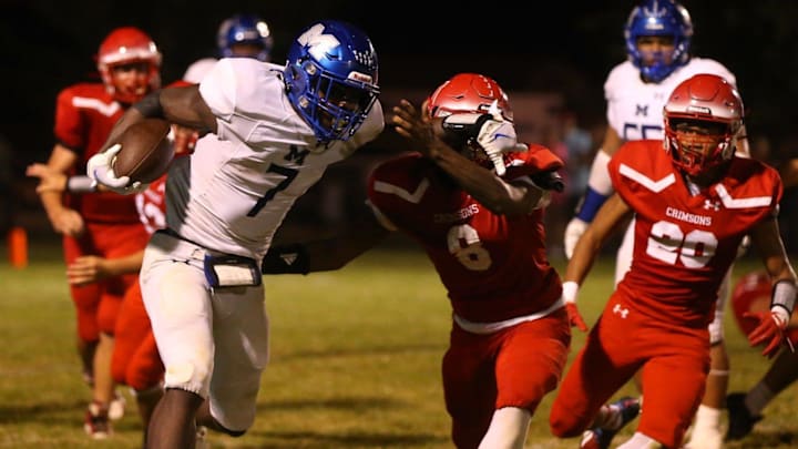 Decatur MacArthur's Myson Johnson-Cook stiff arms a Jacksonville defender during a Central State Eight Conference football game at Kraushaar-Rosenberger Field on Friday, Sept. 1, 2023.