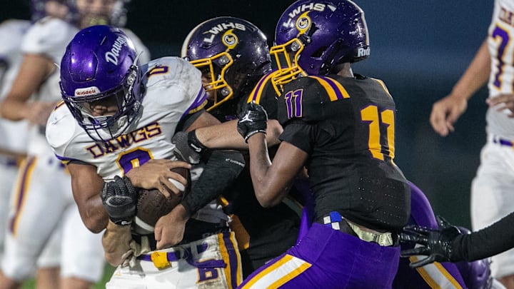 Bell Landin Williams (0) gets grabbed by Lake Weir defenders during a high school football game at Lake Weir High School in Candler, FL on Friday, September 13, 2024. [Alan Youngblood/Ocala Star-Banner]