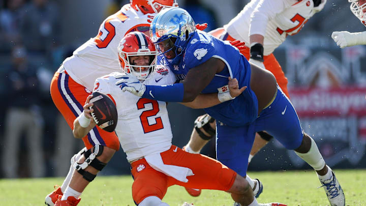 Dec 29, 2023; Jacksonville, FL, USA;  Clemson Tigers quarterback Cade Klubnik (2) is brought down by Kentucky Wildcats defensive lineman Deone Walker (0) in the third quarter during the Gator Bowl at EverBank Stadium. Mandatory Credit: Nathan Ray Seebeck-Imagn Images