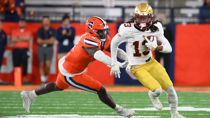Nov 3, 2023; Syracuse, New York, USA; Boston College Eagles wide receiver Dino Tomlin (13) runs with the ball as Syracuse Orange linebacker Marlowe Wax (2) defends during the second half at the JMA Wireless Dome. Mandatory Credit: Rich Barnes-Imagn Images