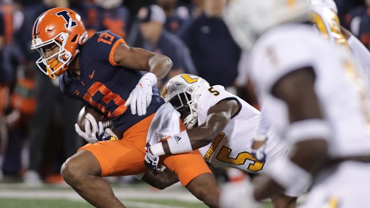 Sep 22, 2022; Champaign, Illinois, USA; Illinois Fighting Illini wide receiver Pat Bryant (13) is tackled by Chattanooga Mocs defensive back CaMiron Smith (5) as he runs with the ball after a short catch during the first half at Memorial Stadium. Mandatory Credit: Ron Johnson-Imagn Images