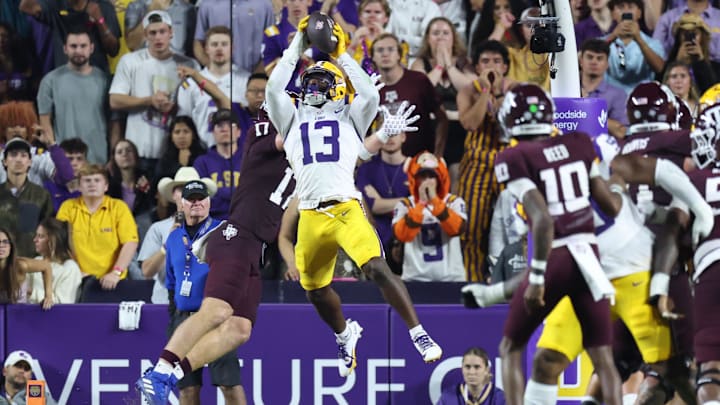 Oct 25, 2025; Baton Rouge, Louisiana, USA; Louisiana State Tigers defensive back A.J. Haulcy (13) makes an interception against Texas A&M Aggies tight end Theo Melin Öhrström (17) during the first half at Tiger Stadium. Mandatory Credit: Stephen Lew-Imagn Images