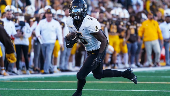 Sep 23, 2023; Laramie, Wyoming, USA; Appalachian State Mountaineers running back Nate Noel (5) runs against the Wyoming Cowboys during the second quarter at Jonah Field at War Memorial Stadium. Mandatory Credit: Troy Babbitt-USA TODAY Sports Sep 23, 2023; Laramie, Wyoming, USA; Appalachian State Mountaineers running back Nate Noel (5) runs against the Wyoming Cowboys during the second quarter at Jonah Field at War Memorial Stadium. Mandatory Credit: Troy Babbitt-USA TODAY Sports