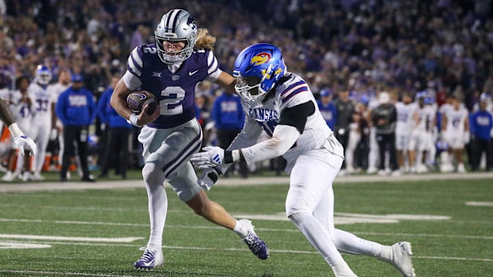 Oct 26, 2024; Manhattan, Kansas, USA; Kansas State Wildcats quarterback Avery Johnson (2) runs by Kansas Jayhawks defensive end Jereme Robinson (90) on his way to a touchdown in the fourth quarter at Bill Snyder Family Football Stadium. Mandatory Credit: Scott Sewell-Imagn Images