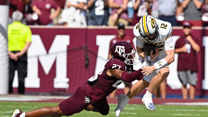 Oct 5, 2024; College Station, Texas, USA; Texas A&M Aggies linebacker Daymion Sanford (27) tackles Missouri Tigers quarterback Brady Cook (12) in the first quarter at Kyle Field. Mandatory Credit: Maria Lysaker-Imagn Images. 