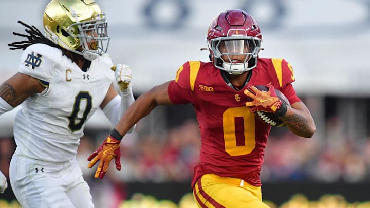 Nov 30, 2024; Los Angeles, California, USA; Southern California Trojans running back Quinten Joyner (0) runs the ball ahead of Notre Dame Fighting Irish safety Xavier Watts (0) during the second half at the Los Angeles Memorial Coliseum. Mandatory Credit: Gary A. Vasquez-Imagn Images Nov 30, 2024; Los Angeles, California, USA; Southern California Trojans running back Quinten Joyner (0) runs the ball ahead of Notre Dame Fighting Irish safety Xavier Watts (0) during the second half at the Los Angeles Memorial Coliseum. Mandatory Credit: Gary A. Vasquez-Imagn Images