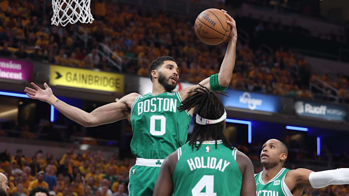 May 25, 2024; Indianapolis, Indiana, USA; Boston Celtics forward Jayson Tatum (0) pulls in a rebound as guard Jrue Holiday (4) and center Al Horford (42) look on during the first quarter of game three of the eastern conference finals against the Indiana Pacers in the 2024 NBA playoffs at Gainbridge Fieldhouse. Mandatory Credit: Trevor Ruszkowski-Imagn Images