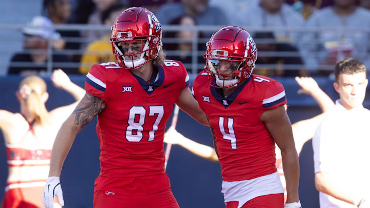 Nov 30, 2024; Tucson, Arizona, USA; Arizona Wildcats wide receiver Tetairoa McMillan (4) celebrates a touchdown with tight end Tyler Powell (87) against the Arizona State Sun Devils during the Territorial Cup at Arizona Stadium. Mandatory Credit: Mark J. Rebilas-Imagn Images