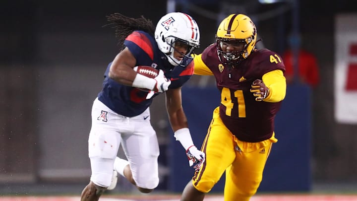 Dec 11, 2020; Tucson, Arizona, USA; Arizona Wildcats running back Gary Brightwell (0) is tackled by Arizona State Sun Devils defensive lineman Tyler Johnson (41) during the Territorial Cup at Arizona Stadium. Mandatory Credit: Mark J. Rebilas-USA TODAY Sport Dec 11, 2020; Tucson, Arizona, USA; Arizona Wildcats running back Gary Brightwell (0) is tackled by Arizona State Sun Devils defensive lineman Tyler Johnson (41) during the Territorial Cup at Arizona Stadium. Mandatory Credit: Mark J. Rebilas-USA TODAY Sport