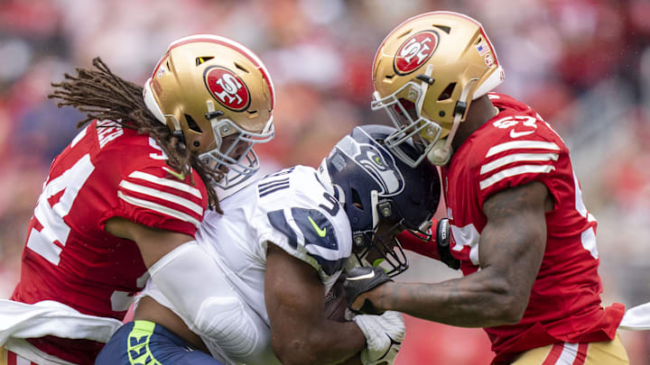 Seattle Seahawks running back Kenneth Walker III is tackled by San Francisco 49ers linebackers Fred Warner and Dre Greenlaw