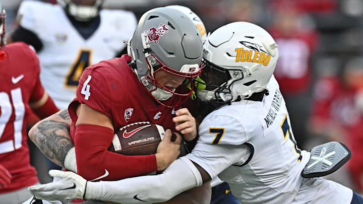 Oct 25, 2025; Pullman, Washington, USA; Washington State Cougars quarterback Zevi Eckhaus (4) is tackled by Toledo Rockets safety Emmanuel McNeil-Warren (7) in the second half at Gesa Field at Martin Stadium. Mandatory Credit: James Snook-Imagn Images