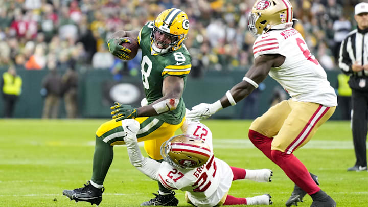 Nov 24, 2024; Green Bay, Wisconsin, USA;  Green Bay Packers running back Josh Jacobs (8) is tackled by San Francisco 49ers safety Ji'Ayir Brown (27) during the first quarter at Lambeau Field. Mandatory Credit: Jeff Hanisch-Imagn Images