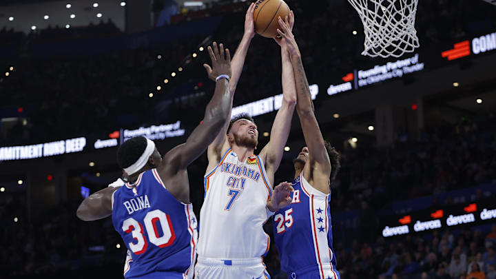 Dec 28, 2025; Oklahoma City, Oklahoma, USA; Oklahoma City Thunder center Chet Holmgren (7) goes up for a basket between Philadelphia 76ers forward Dominick Barlow (25) and center Adem Bona (30) during the second half at Paycom Center. Mandatory Credit: Alonzo Adams-Imagn Images