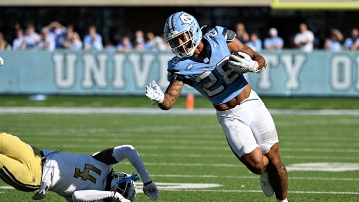 Oct 12, 2024; Chapel Hill, North Carolina, USA;  North Carolina Tar Heels running back Omarion Hampton (28) with the ball as Georgia Tech Yellow Jackets defensive back Warren Burrell (4) defends in the fourth quarter at Kenan Memorial Stadium. Mandatory Credit: Bob Donnan-Imagn Images