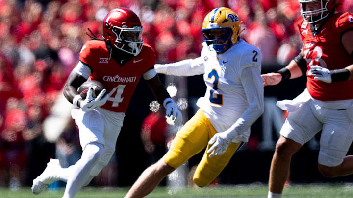 Cincinnati Bearcats wide receiver Tyrin Smith (4) runs as Pittsburgh Panthers defensive lineman Nate Matlack (2) attempts to stop him in the second quarter of the College Football game at Nippert Stadium in Cincinnati on Saturday, Sept. 7, 2024.