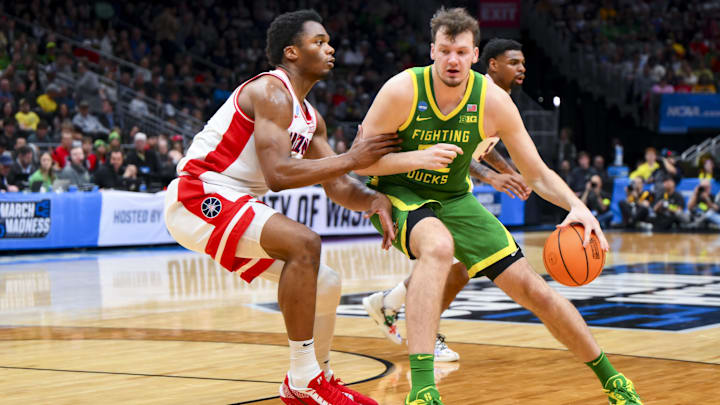 Mar 23, 2025; Seattle, WA, USA;  Oregon Ducks center Nate Bittle (32) dribbles the ball against Arizona Wildcats forward Tobe Awaka (30) in the first half at Climate Pledge Arena. Mandatory Credit: Steven Bisig-Imagn Images