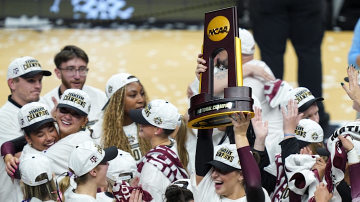 Dec 21, 2025; Kansas City, MO, USA; Texas A&M Aggies opposite Logan Lednicky (9) hoists the 2025 NCAA Women’s Volleyball Championship trophy after defeating the Kentucky Wildcats at T-Mobile Center. Mandatory Credit: Jay Biggerstaff-Imagn Images