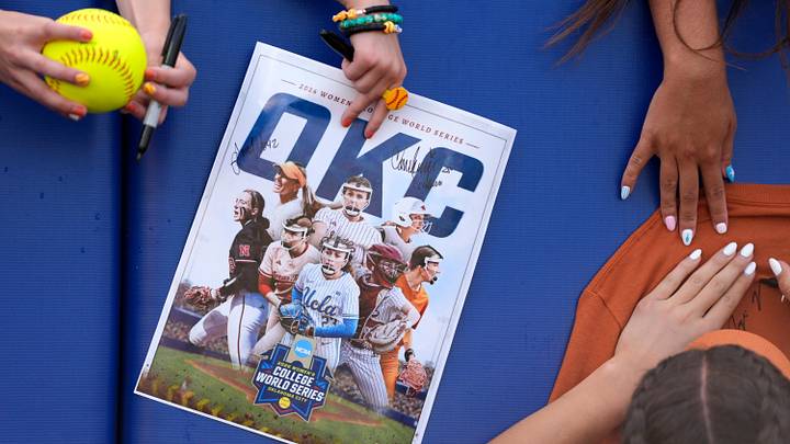 Fans hold items for Texas players to sign before Game 1 of the NCAA softball Women's College World Series finals between the Texas Longhorns and the Texas Tech Red Raiders at Devon Park in Oklahoma City, Wednesday, June 3, 2026.