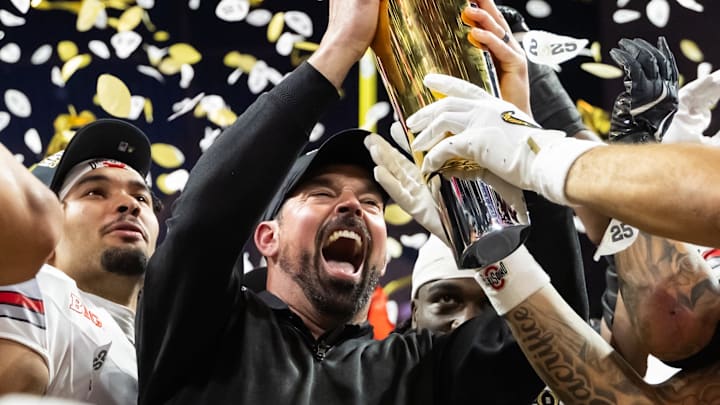 Jan 20, 2025; Atlanta, GA, USA; Ohio State Buckeyes head coach Ryan Day hoists the trophy as he celebrates with his players after defeating the Notre Dame Fighting Irish during the CFP National Championship college football game at Mercedes-Benz Stadium. Mandatory Credit: Mark J. Rebilas-Imagn Images Jan 20, 2025; Atlanta, GA, USA; Ohio State Buckeyes head coach Ryan Day hoists the trophy as he celebrates with his players after defeating the Notre Dame Fighting Irish during the CFP National Championship college football game at Mercedes-Benz Stadium. Mandatory Credit: Mark J. Rebilas-Imagn Images
