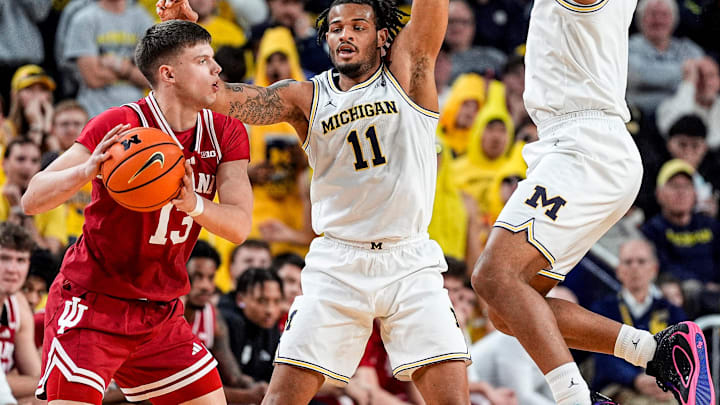 Michigan guard Roddy Gayle Jr. (11) and guard Trey McKenney (1) defend Indiana guard Aleksa Ristic (13) during the second half at Crisler Center in Ann Arbor on Tuesday, Jan. 20, 2026.
