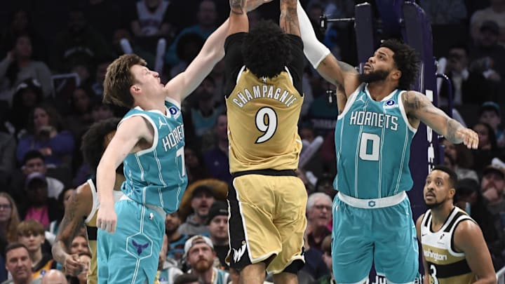 Dec 23, 2025; Charlotte, North Carolina, USA;  Washington Wizards forward Justin Champagnie (9) drives in past Charlotte Hornets forward Koa Knueppel (7) and forward Miles Bridges (0) during the second half at the Spectrum Center. Mandatory Credit: Sam Sharpe-Imagn Images